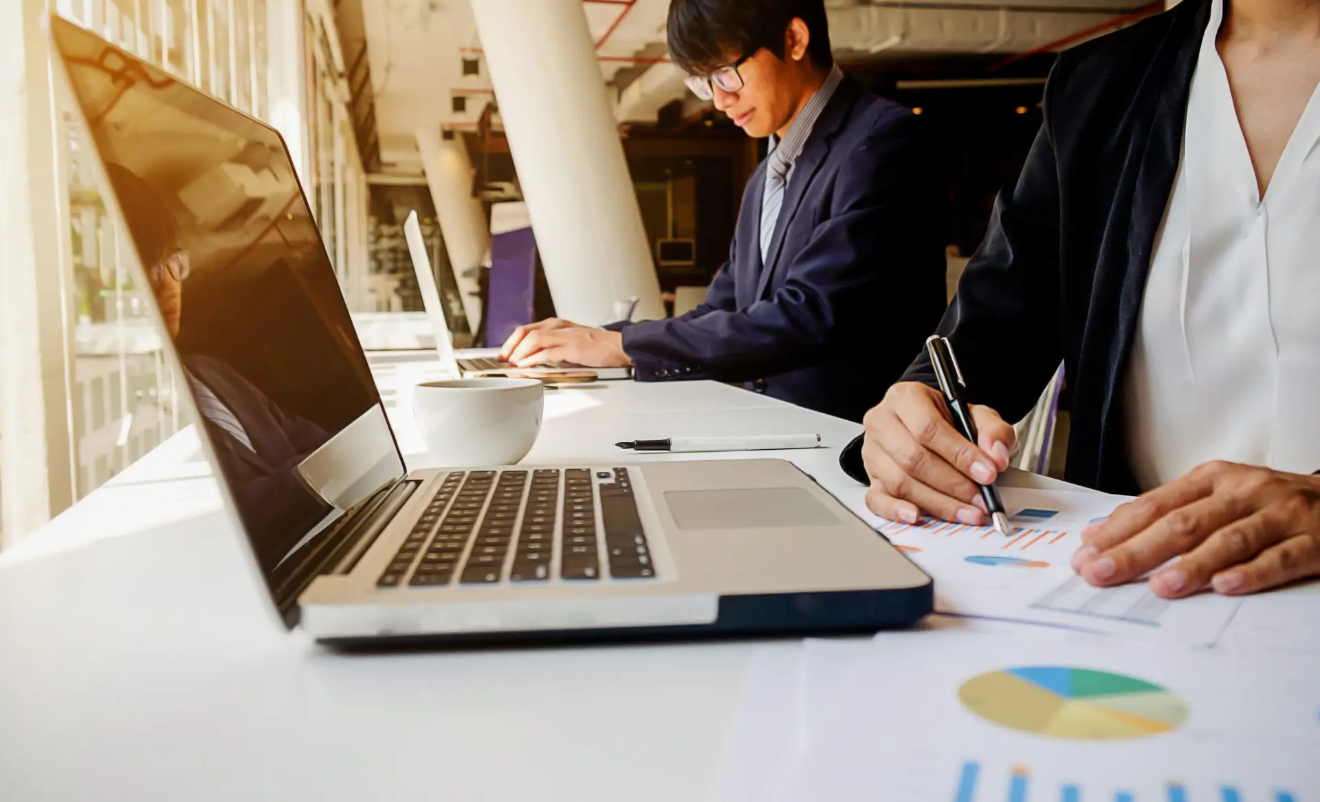 Business concept. Business people discussing the charts and graphs showing the results of their successful teamwork. Selective focus.